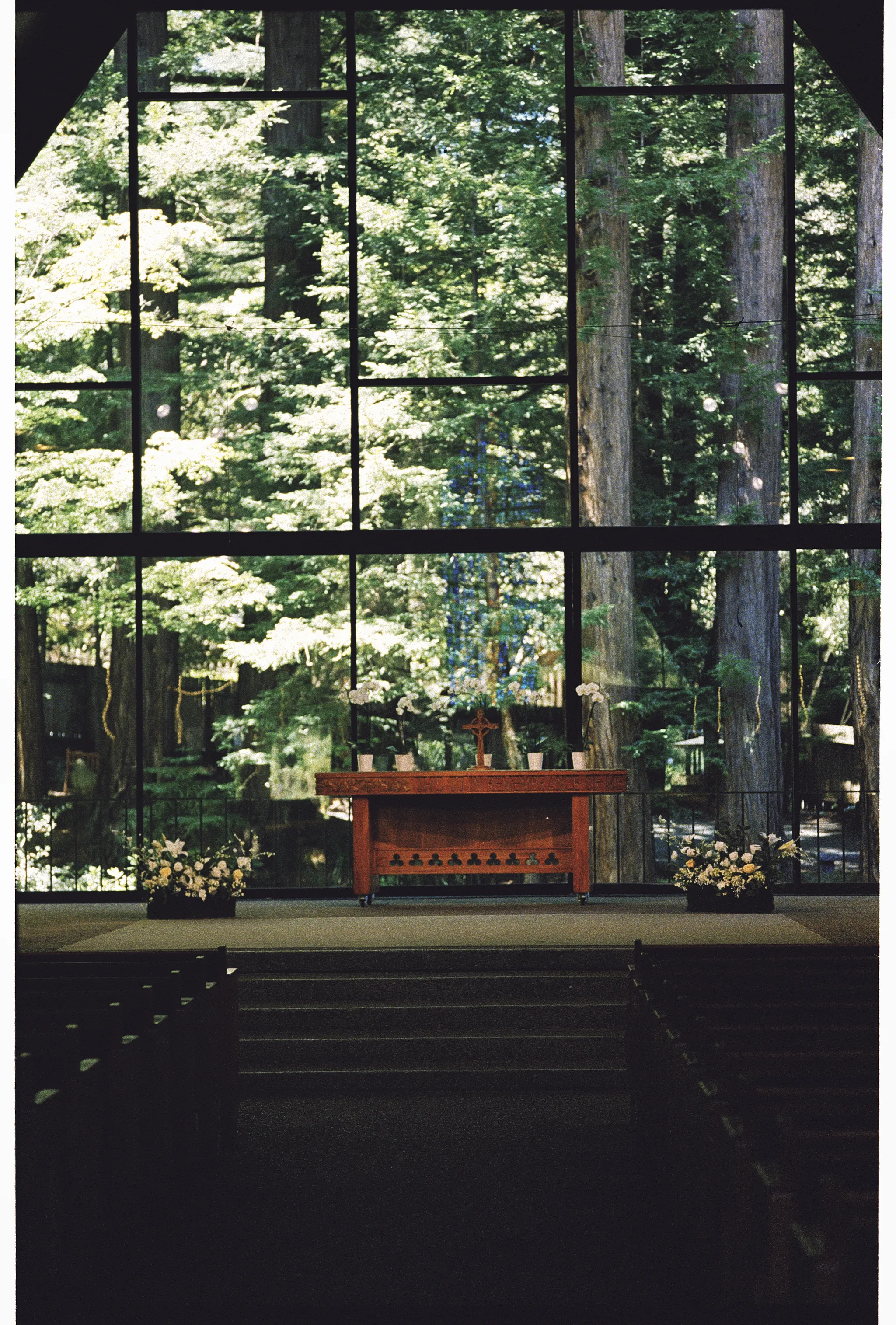 White floral arrangements in a redwood chapel ceremony space